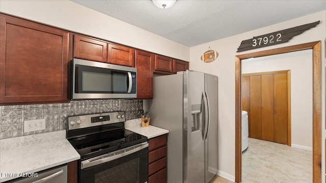 300 Clearfield Rd, Knoxville, TN 37922 - kitchen featuring stainless steel appliances, decorative backsplash, a textured ceiling, washer / dryer, and light stone counters
