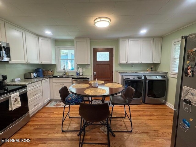 3207 Dove Ln, White Pine, TN 37890 - kitchen with stainless steel appliances, washer and dryer, white cabinetry, and light wood-type flooring