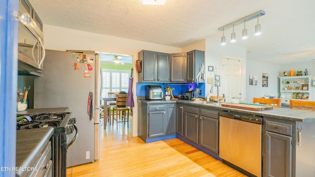 1517 Randal Park Dr, Knoxville, TN 37922 - kitchen featuring appliances with stainless steel finishes, a ceiling fan, light wood-type flooring, a peninsula, and a textured ceiling