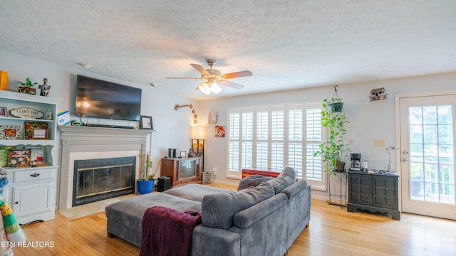 1517 Randal Park Dr, Knoxville, TN 37922 - living room with light wood-style floors, a ceiling fan, a textured ceiling, and a glass covered fireplace