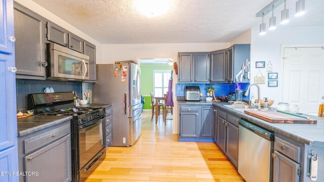 1517 Randal Park Dr, Knoxville, TN 37922 - kitchen featuring appliances with stainless steel finishes, light wood finished floors, backsplash, a textured ceiling, and ceiling fan