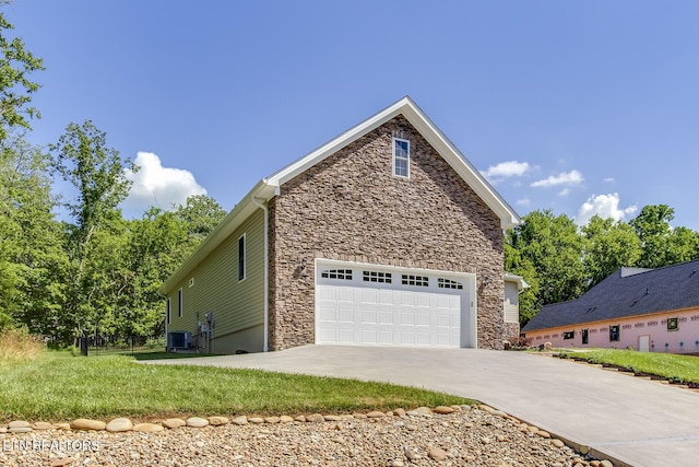 129 Dudi Trl, Vonore, TN 37885 - view of home's exterior with stone siding, driveway, and an attached garage