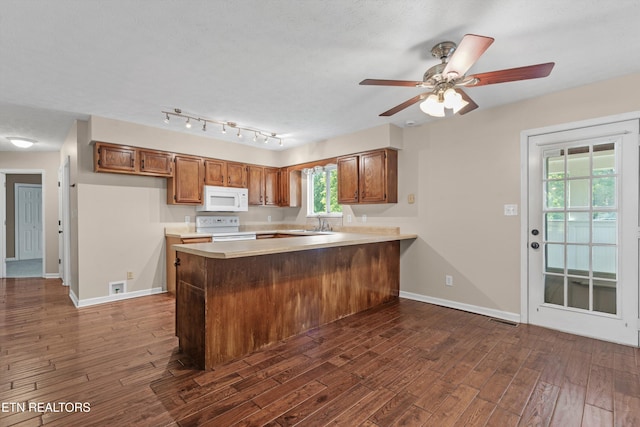 10609 Sprawls Pt, Knoxville, TN 37932 - kitchen with white appliances, brown cabinetry, a peninsula, and dark wood-type flooring