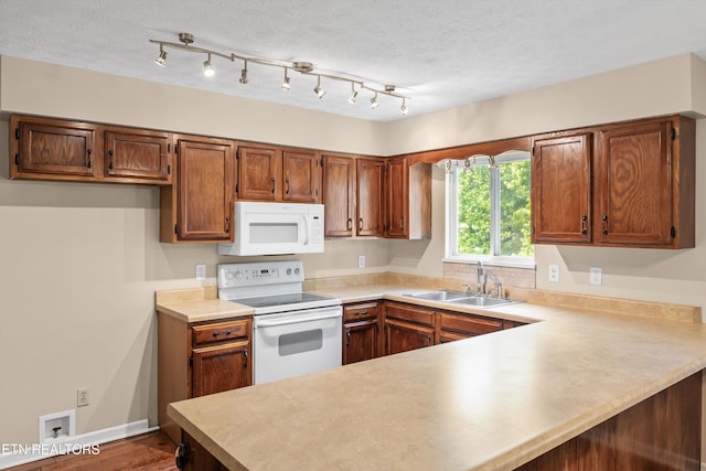 10609 Sprawls Pt, Knoxville, TN 37932 - kitchen featuring white appliances, a peninsula, light countertops, brown cabinetry, and dark wood-style flooring