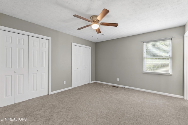 10609 Sprawls Pt, Knoxville, TN 37932 - unfurnished bedroom featuring carpet floors, multiple closets, a textured ceiling, and a ceiling fan