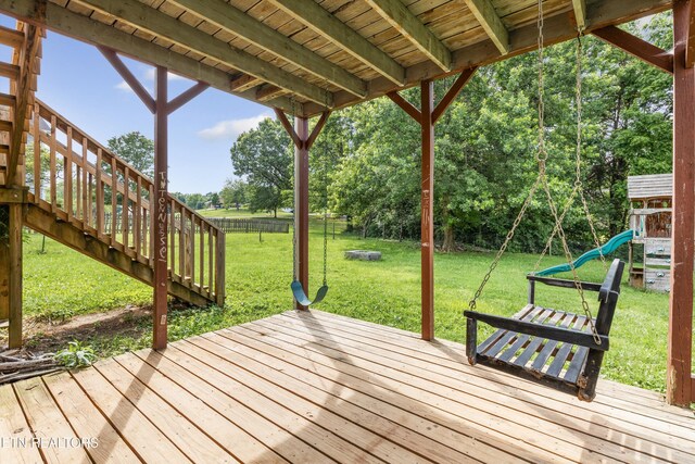10609 Sprawls Pt, Knoxville, TN 37932 - deck with a playground, a fenced backyard, stairway, and view of wooded area