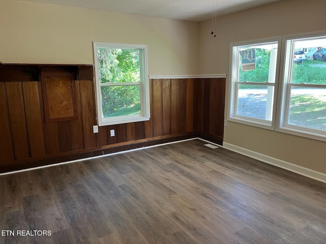 913 S Cumberland Ave, Lafollette, TN 37766 - unfurnished room featuring wood finished floors, healthy amount of natural light, a wainscoted wall, and wooden walls