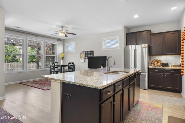 10703 Grantham Ln, Knoxville, TN 37932 - kitchen featuring ceiling fan, light wood-style floors, stainless steel appliances, dark brown cabinets, and light stone countertops