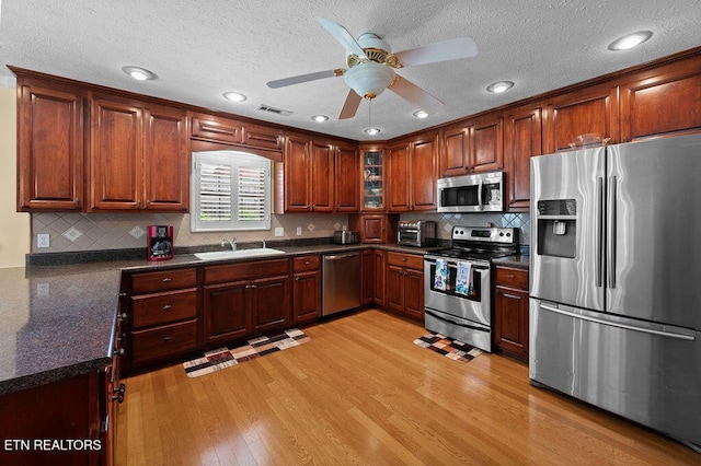 674 Southview Cir, Kodak, TN 37764 - kitchen with appliances with stainless steel finishes, light wood-style flooring, a ceiling fan, tasteful backsplash, and a textured ceiling