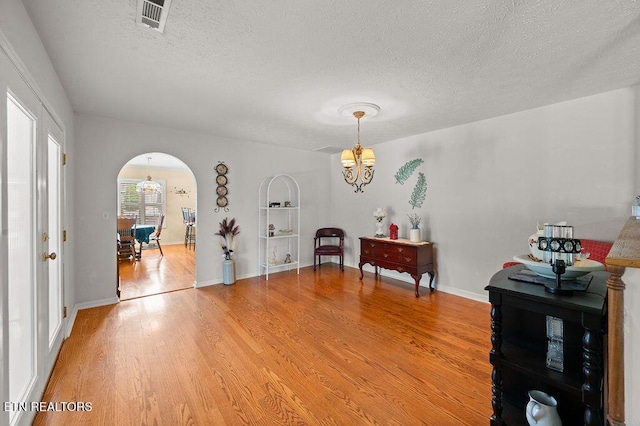674 Southview Cir, Kodak, TN 37764 - living area featuring a chandelier, light wood-style flooring, arched walkways, and a textured ceiling