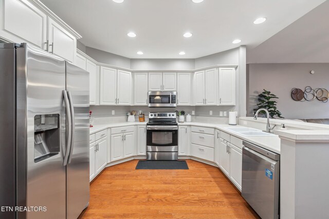 121 Fallberry St, Oak Ridge, TN 37830 - kitchen featuring appliances with stainless steel finishes, light countertops, white cabinets, recessed lighting, and a peninsula