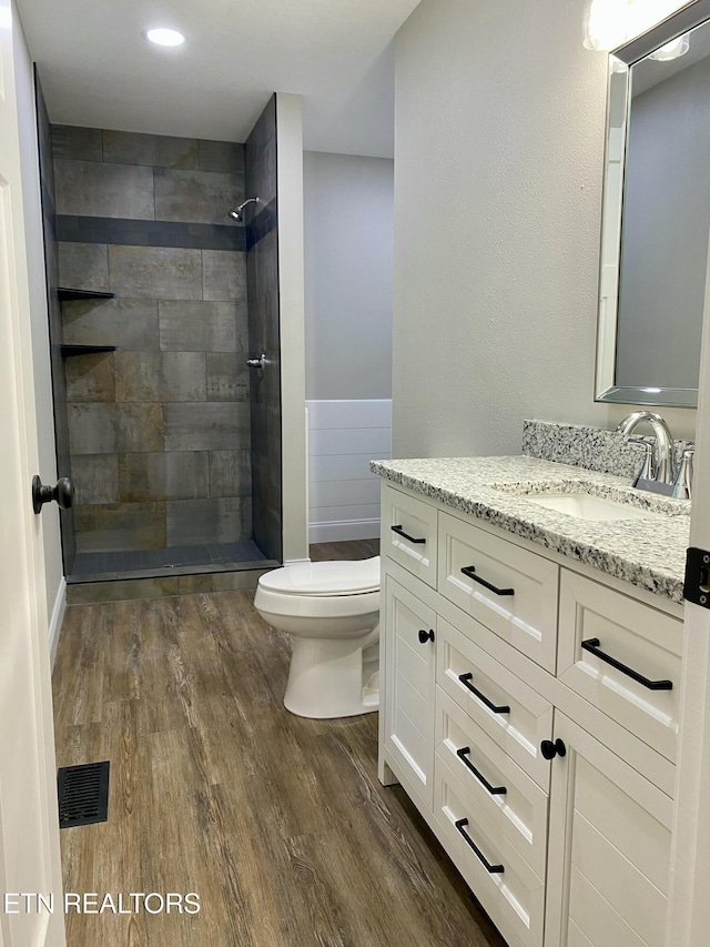 506 Snead Dr, Crossville, TN 38572 - full bathroom with vanity, wood finished floors, tiled shower, and a wainscoted wall