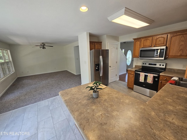 209 Cherokee Trl, Seymour, TN 37865 - kitchen featuring stainless steel appliances, light carpet, a ceiling fan, brown cabinets, and recessed lighting