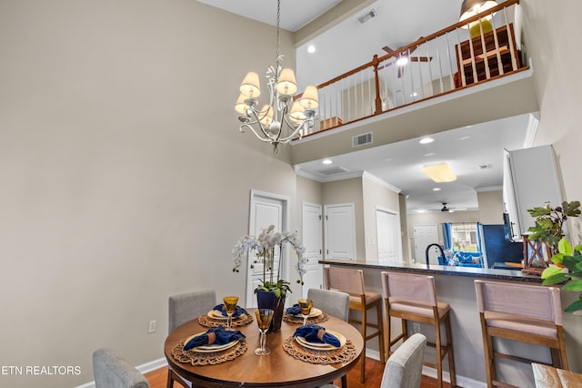 10867 Carpenter Run Ln Unit 44, Knoxville, TN 37932 - dining room with a towering ceiling, crown molding, a chandelier, wood finished floors, and recessed lighting