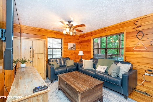 1507 Boo Boos Way, Sevierville, TN 37862 - living room featuring plenty of natural light, a ceiling fan, wood walls, and a textured ceiling