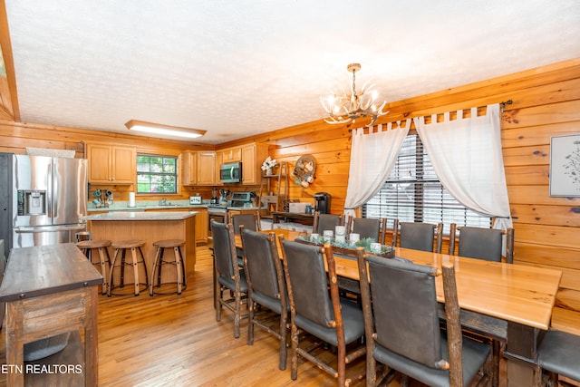 1507 Boo Boos Way, Sevierville, TN 37862 - dining area with light wood-style flooring, a chandelier, wooden walls, and a textured ceiling