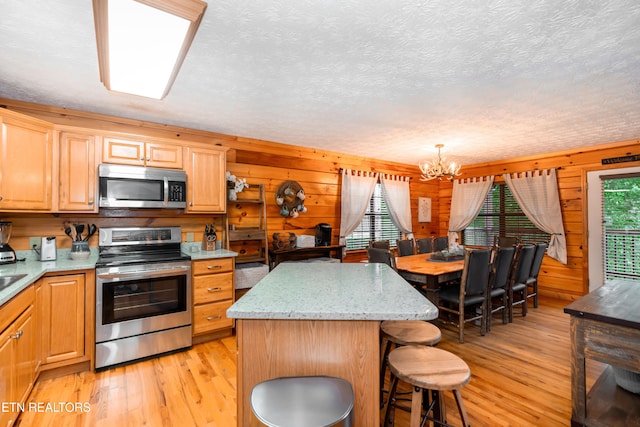 1507 Boo Boos Way, Sevierville, TN 37862 - kitchen with stainless steel appliances, light wood-style floors, a chandelier, a center island, and a textured ceiling
