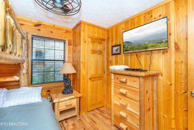 1507 Boo Boos Way, Sevierville, TN 37862 - bedroom featuring wood walls, light wood-style flooring, and a textured ceiling