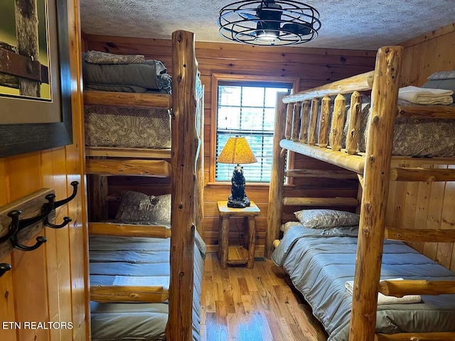 1507 Boo Boos Way, Sevierville, TN 37862 - bedroom featuring wooden walls, wood finished floors, and a textured ceiling