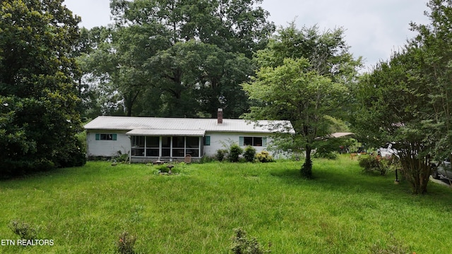 393 SW Sim Goodwin Rd, Mcdonald, TN 37353 - back of property featuring a sunroom, a chimney, a yard, and a metal roof