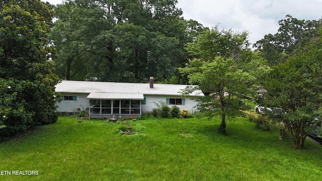 393 SW Sim Goodwin Rd, Mcdonald, TN 37353 - back of house with a sunroom, a lawn, a metal roof, and a chimney