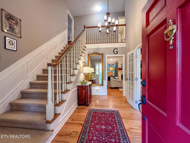 12218 Torrey Pines Pt, Knoxville, TN 37934 - entryway featuring a chandelier, stairway, french doors, light wood finished floors, and a decorative wall