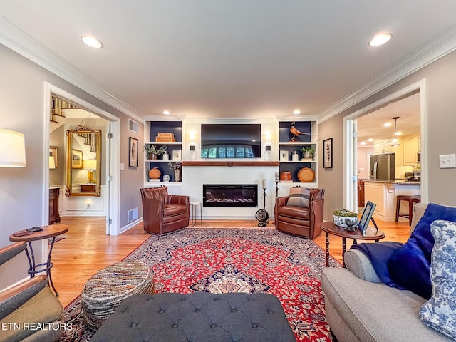 12218 Torrey Pines Pt, Knoxville, TN 37934 - living area with ornamental molding, light wood finished floors, a glass covered fireplace, recessed lighting, and built in shelves