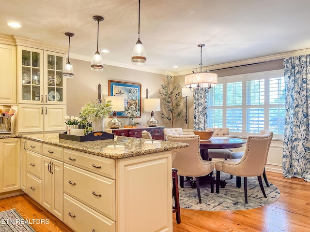 12218 Torrey Pines Pt, Knoxville, TN 37934 - kitchen with crown molding, light wood-style floors, light stone countertops, glass insert cabinets, and decorative light fixtures