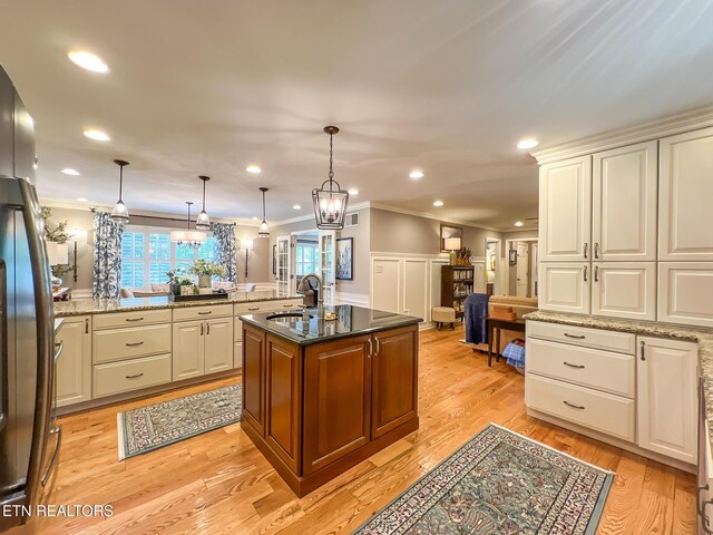 12218 Torrey Pines Pt, Knoxville, TN 37934 - kitchen with ornamental molding, open floor plan, freestanding refrigerator, light stone counters, and decorative light fixtures