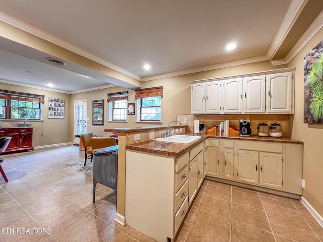 12218 Torrey Pines Pt, Knoxville, TN 37934 - kitchen featuring a peninsula, healthy amount of natural light, ornamental molding, a kitchen breakfast bar, and light tile patterned floors