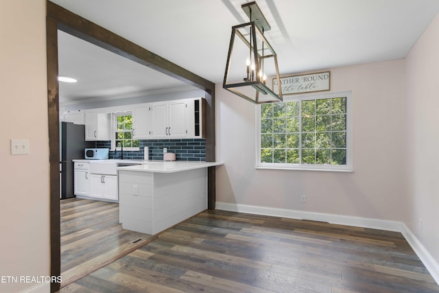 101 Concord Rd, Oak Ridge, TN 37830 - kitchen featuring a peninsula, white microwave, white cabinets, and backsplash