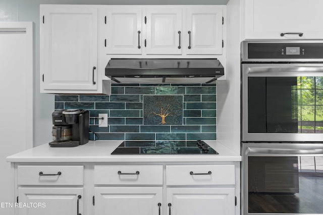 101 Concord Rd, Oak Ridge, TN 37830 - kitchen with double oven, under cabinet range hood, black electric cooktop, white cabinetry, and backsplash