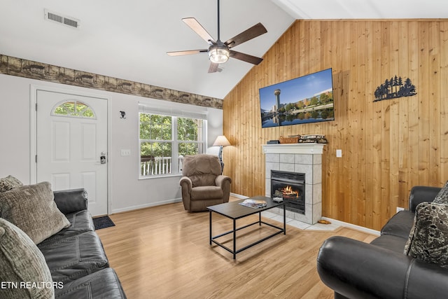 814 Plantation Dr, Pigeon Forge, TN 37863 - living area with wooden walls, ceiling fan, wood finished floors, a tile fireplace, and high vaulted ceiling