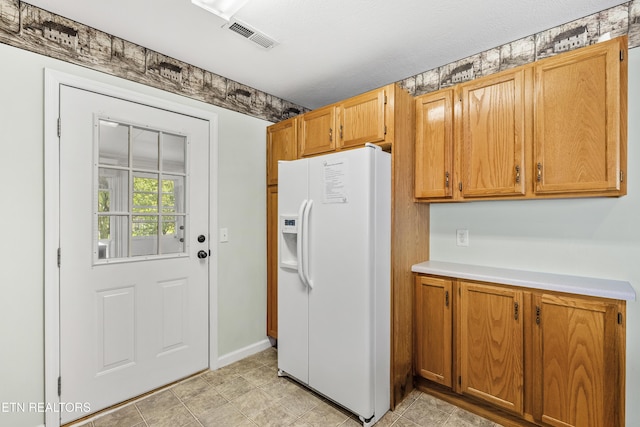814 Plantation Dr, Pigeon Forge, TN 37863 - kitchen featuring white refrigerator with ice dispenser, light countertops, and brown cabinetry