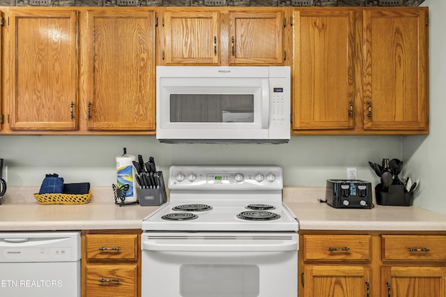 814 Plantation Dr, Pigeon Forge, TN 37863 - kitchen with white appliances, light countertops, and brown cabinetry