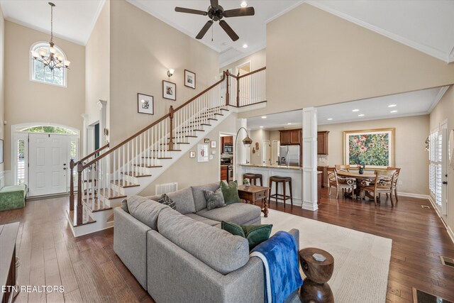 1213 Whisper Trace Ln, Knoxville, TN 37919 - living room featuring a high ceiling, stairs, dark wood-type flooring, ceiling fan, and crown molding