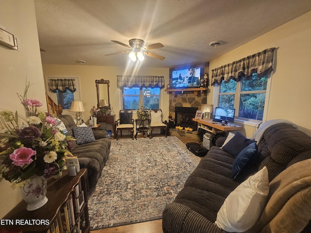 199 Pear Tree Way, Del Rio, TN 37727 - living area featuring a ceiling fan, a stone fireplace, wood finished floors, and a textured ceiling