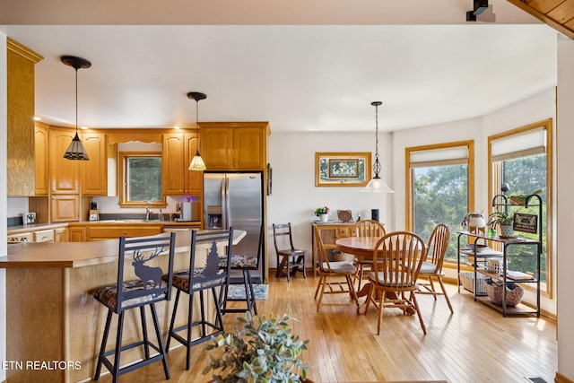 3930 Settlers Trl, Kodak, TN 37764 - kitchen with stainless steel refrigerator with ice dispenser, light wood-style flooring, a breakfast bar, and decorative light fixtures