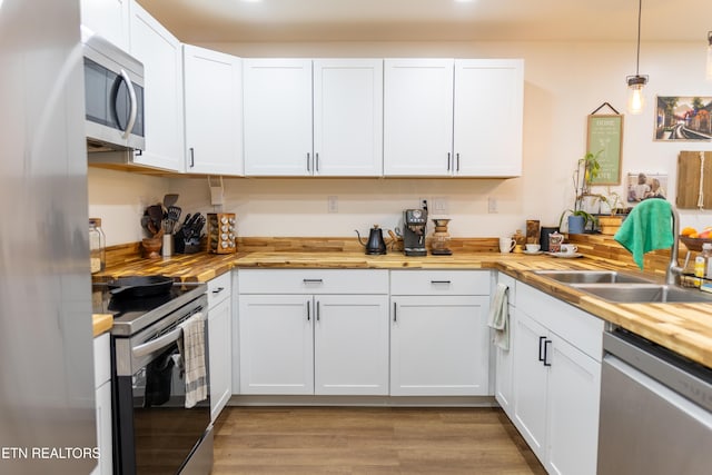 1210 Frank Campbell Rd, Jamestown, TN 38556 - kitchen featuring appliances with stainless steel finishes, wood counters, white cabinetry, and pendant lighting