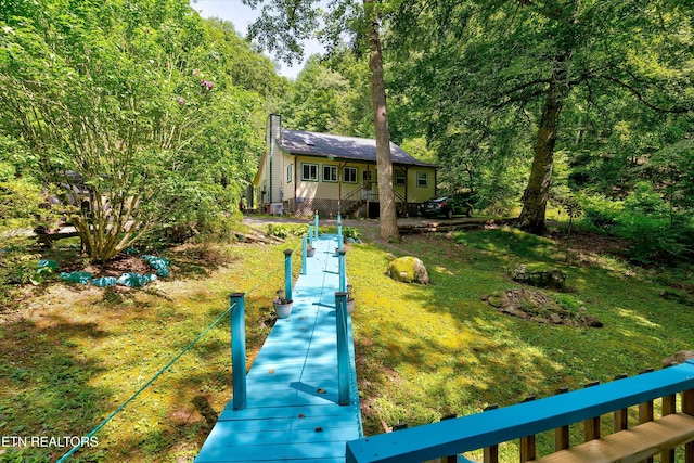 3255 Bear Mountain Ln, Sevierville, TN 37876 - back of property with a chimney, a lawn, and a forest view