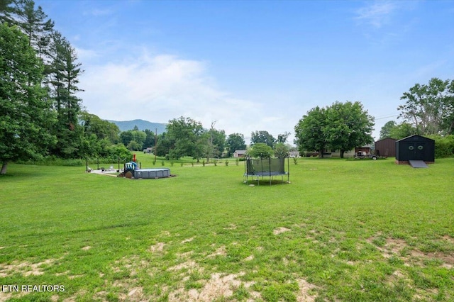 226 Hilldale Ln, Lafollette, TN 37766 - view of grassy yard featuring a trampoline, a shed, and a mountain view