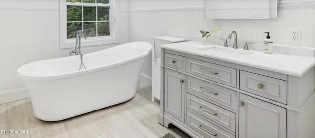 3402 Lillie Blvd, Sevierville, TN 37876 - bathroom featuring vanity, a freestanding tub, and wood finished floors