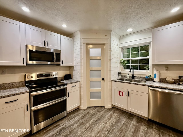 3402 Lillie Blvd, Sevierville, TN 37876 - kitchen featuring stainless steel appliances, a textured ceiling, dark wood finished floors, white cabinets, and recessed lighting
