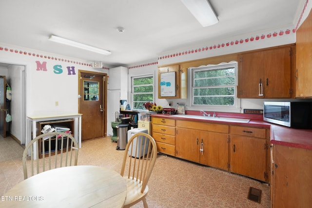 1415 Ebenezer Rd, Knoxville, TN 37922 - kitchen featuring stainless steel microwave, light flooring, and brown cabinetry