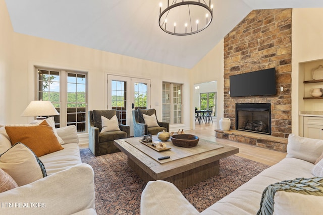200 Stony Rock Ln, Jacksboro, TN 37757 - living room with a chandelier, plenty of natural light, a stone fireplace, wood finished floors, and high vaulted ceiling