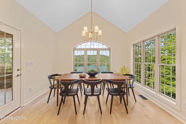 200 Stony Rock Ln, Jacksboro, TN 37757 - dining space with light wood-style flooring, a water view, vaulted ceiling, a chandelier, and plenty of natural light