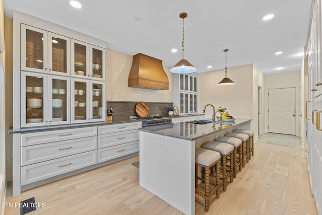 200 Stony Rock Ln, Jacksboro, TN 37757 - kitchen featuring premium range hood, dark stone countertops, a kitchen breakfast bar, glass insert cabinets, and recessed lighting