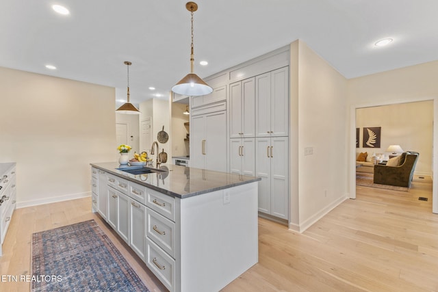 200 Stony Rock Ln, Jacksboro, TN 37757 - kitchen featuring light wood-type flooring, an island with sink, recessed lighting, pendant lighting, and dark stone countertops