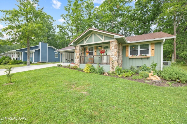 137 Jasper Dr, Crossville, TN 38558 - view of front of house with concrete driveway, covered porch, a front yard, and a metal roof