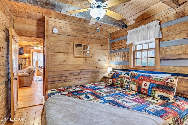 1505 Dawn Ln, Sevierville, TN 37876 - bedroom featuring wooden walls, a wooden ceiling with exposed beams, multiple windows, and hardwood / wood-style flooring